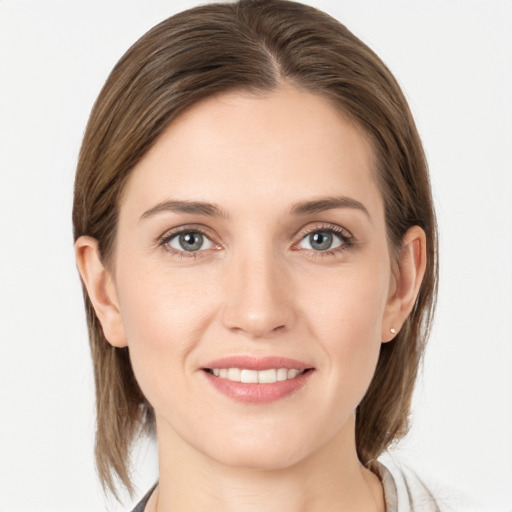 Joyful white young-adult female with medium  brown hair and grey eyes