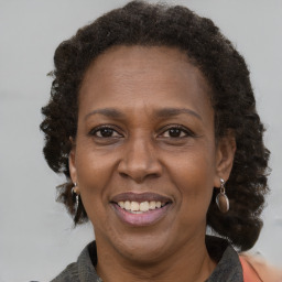 Joyful black adult female with medium  brown hair and brown eyes