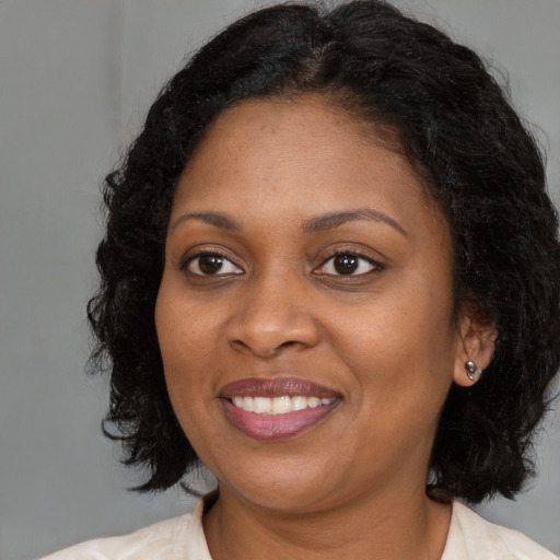 Joyful black young-adult female with medium  brown hair and brown eyes