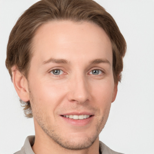 Joyful white young-adult male with short  brown hair and grey eyes