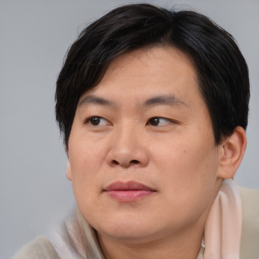 Joyful asian young-adult male with medium  brown hair and brown eyes