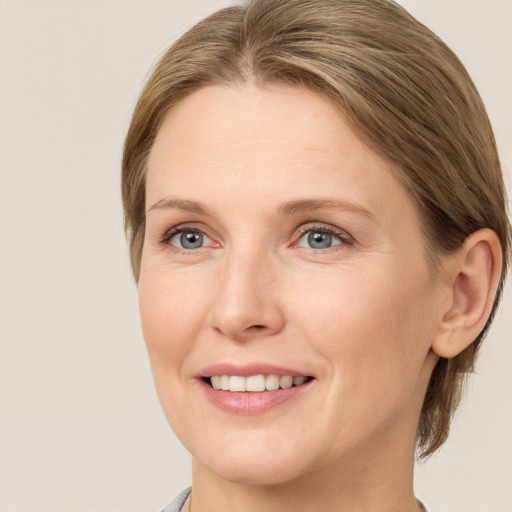 Joyful white young-adult female with medium  brown hair and green eyes