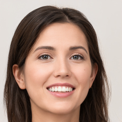 Joyful white young-adult female with long  brown hair and brown eyes