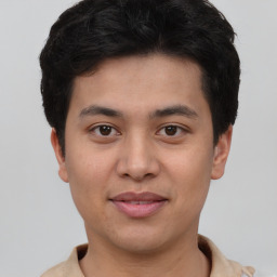 Joyful latino young-adult male with short  brown hair and brown eyes