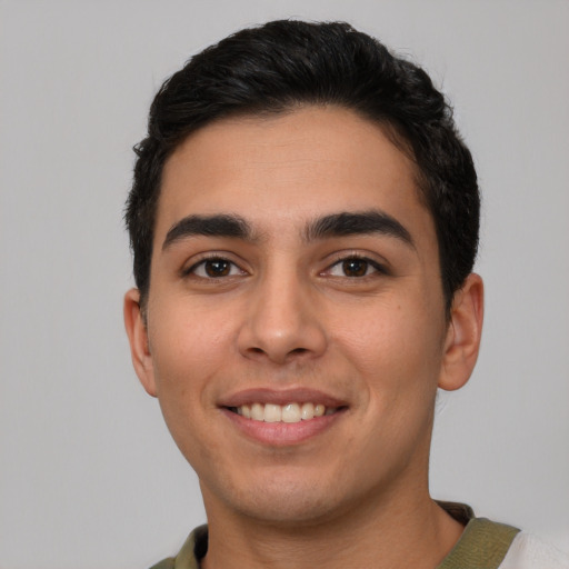 Joyful latino young-adult male with short  black hair and brown eyes