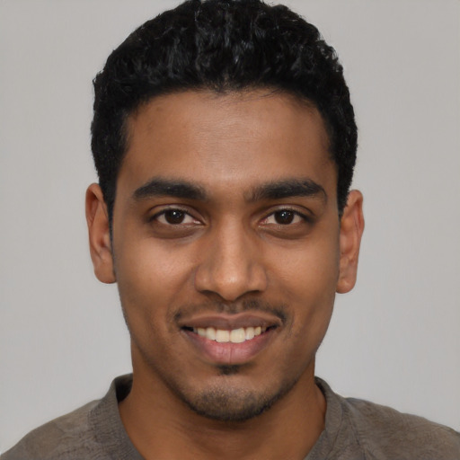 Joyful latino young-adult male with short  black hair and brown eyes