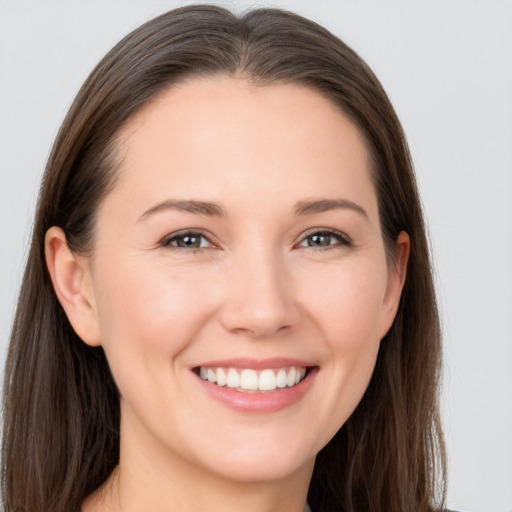 Joyful white young-adult female with long  brown hair and brown eyes