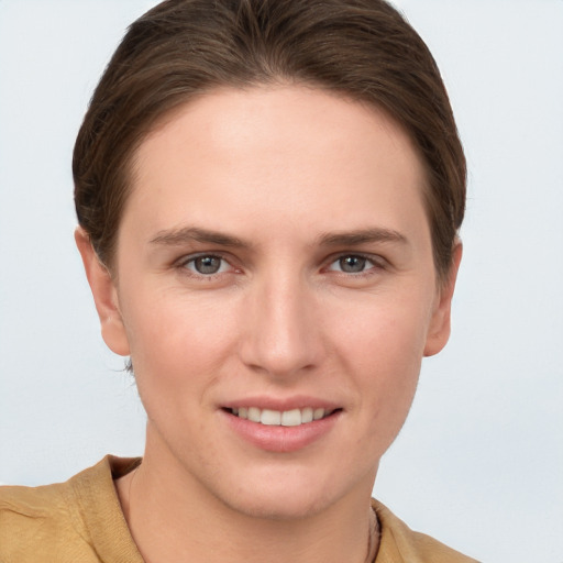 Joyful white young-adult female with short  brown hair and grey eyes