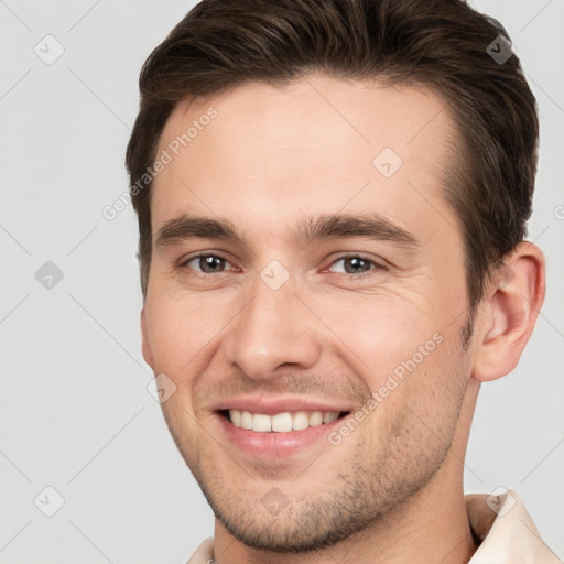 Joyful white young-adult male with short  brown hair and brown eyes