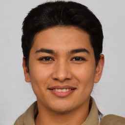 Joyful latino young-adult male with short  brown hair and brown eyes
