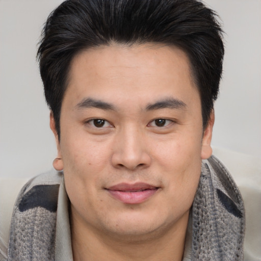 Joyful asian young-adult male with short  brown hair and brown eyes