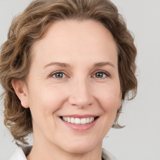 Joyful white young-adult female with medium  brown hair and green eyes