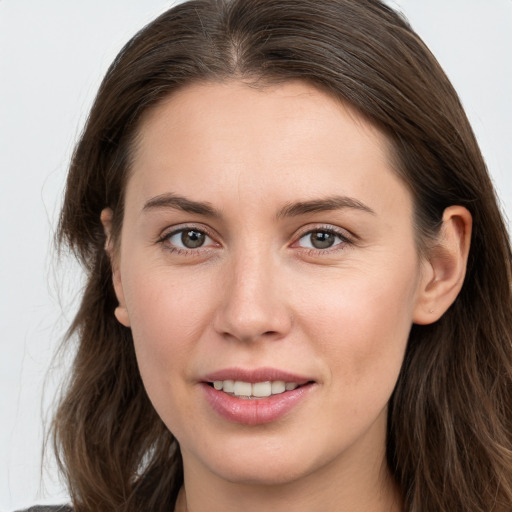 Joyful white young-adult female with long  brown hair and grey eyes