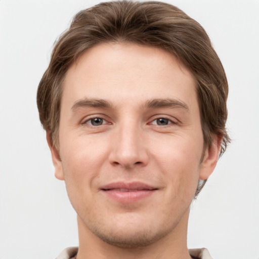 Joyful white young-adult male with short  brown hair and grey eyes