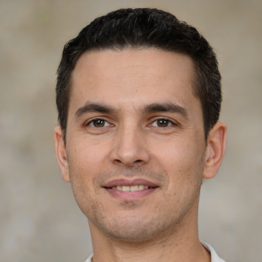 Joyful white young-adult male with short  black hair and brown eyes