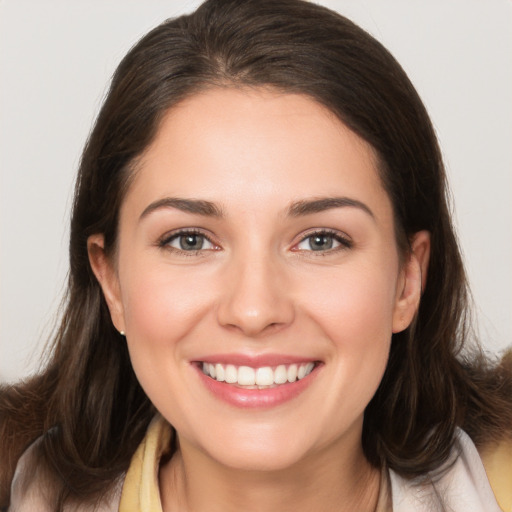 Joyful white young-adult female with long  brown hair and brown eyes