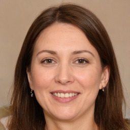 Joyful white adult female with long  brown hair and brown eyes