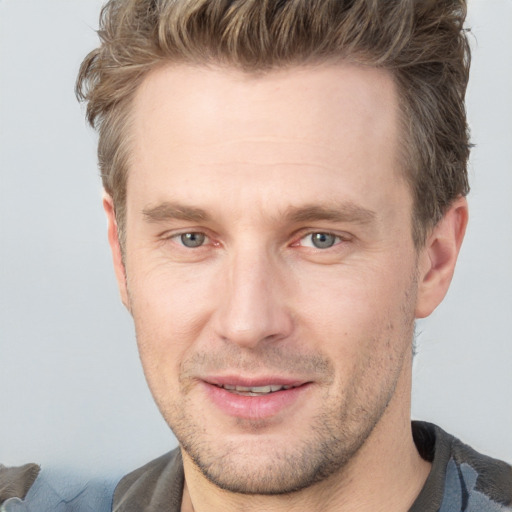 Joyful white adult male with short  brown hair and grey eyes