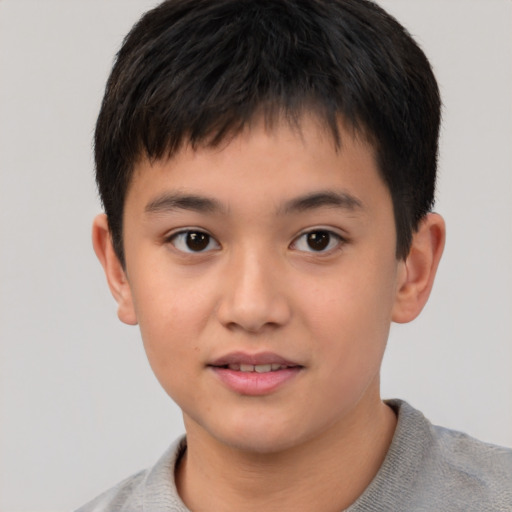 Joyful asian child male with short  brown hair and brown eyes
