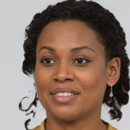 Joyful black young-adult female with medium  brown hair and brown eyes