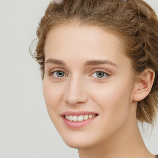 Joyful white young-adult female with long  brown hair and blue eyes