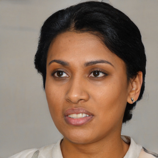 Joyful black young-adult female with medium  black hair and brown eyes