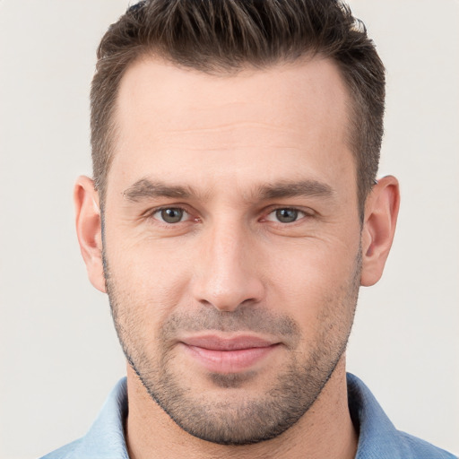 Joyful white young-adult male with short  brown hair and grey eyes