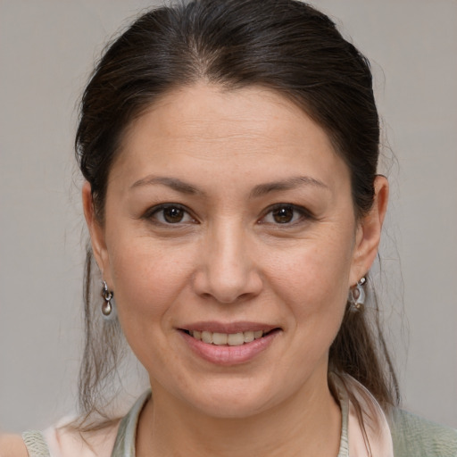 Joyful white adult female with medium  brown hair and brown eyes