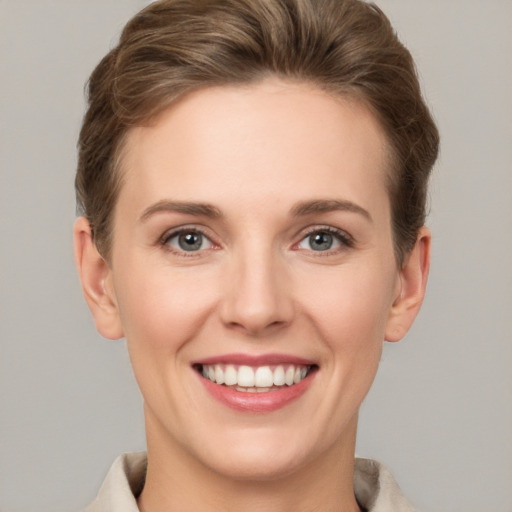 Joyful white young-adult female with short  brown hair and grey eyes