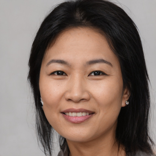 Joyful asian adult female with long  brown hair and brown eyes
