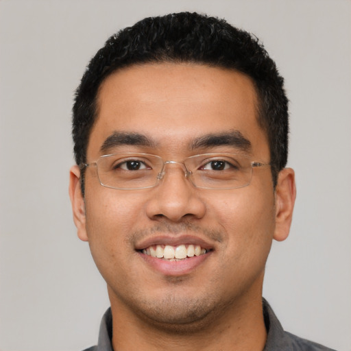 Joyful latino young-adult male with short  black hair and brown eyes