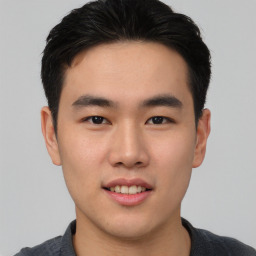 Joyful asian young-adult male with short  black hair and brown eyes