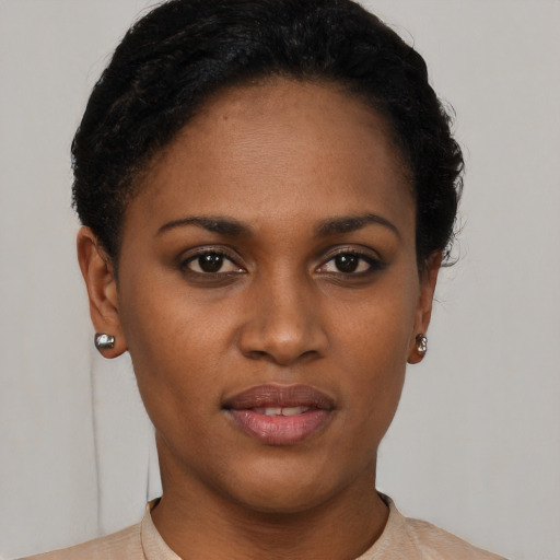 Joyful black young-adult female with short  black hair and brown eyes
