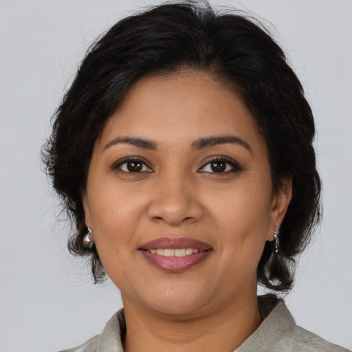 Joyful latino adult female with medium  brown hair and brown eyes