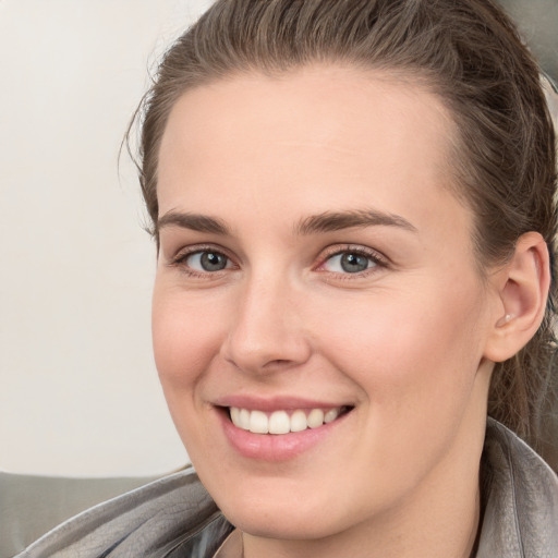 Joyful white young-adult female with long  brown hair and grey eyes