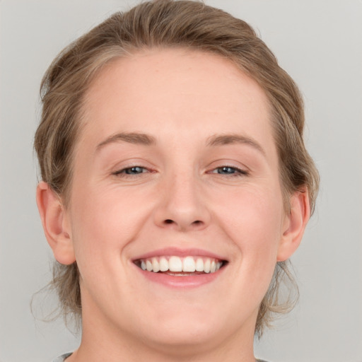 Joyful white young-adult female with medium  brown hair and blue eyes