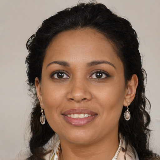 Joyful black young-adult female with long  brown hair and brown eyes