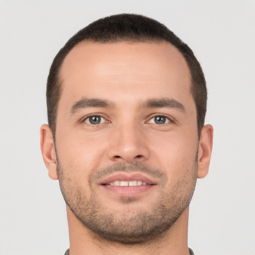 Joyful white young-adult male with short  brown hair and brown eyes