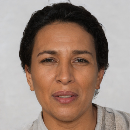 Joyful latino adult female with short  brown hair and brown eyes