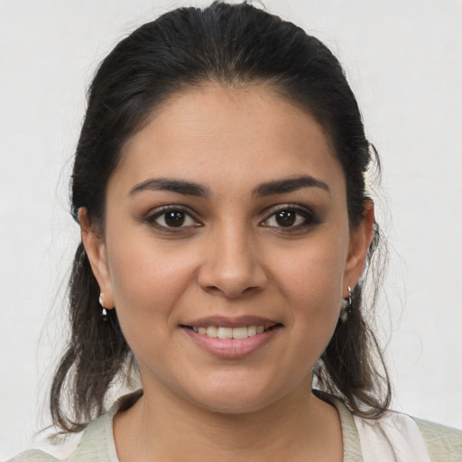 Joyful latino young-adult female with medium  brown hair and brown eyes