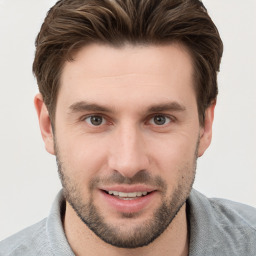 Joyful white young-adult male with short  brown hair and grey eyes