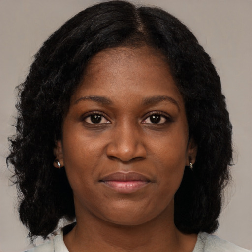 Joyful black young-adult female with medium  brown hair and brown eyes