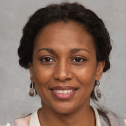 Joyful black adult female with short  brown hair and brown eyes