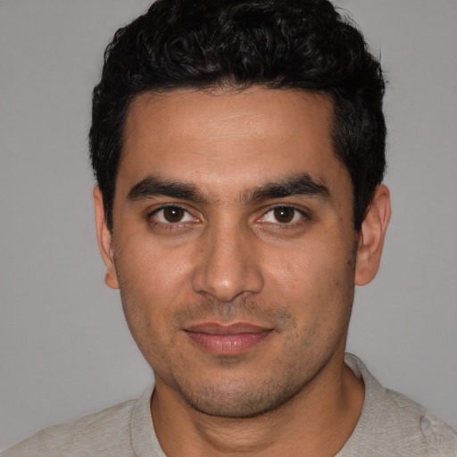 Joyful latino young-adult male with short  black hair and brown eyes