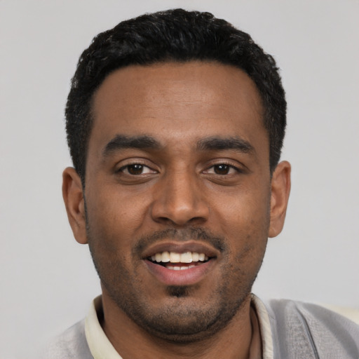 Joyful black young-adult male with short  black hair and brown eyes