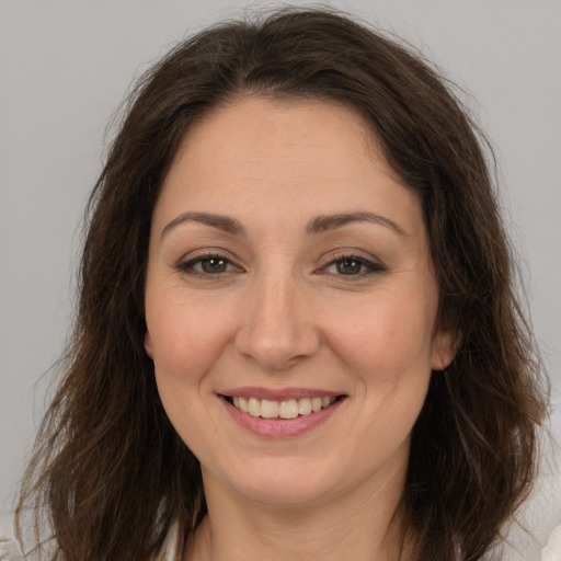 Joyful white adult female with long  brown hair and brown eyes