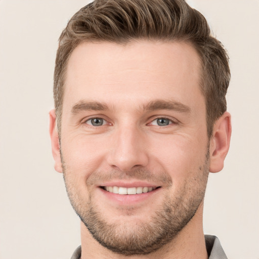 Joyful white young-adult male with short  brown hair and grey eyes