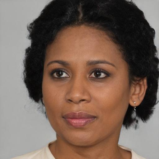 Joyful black young-adult female with medium  brown hair and brown eyes
