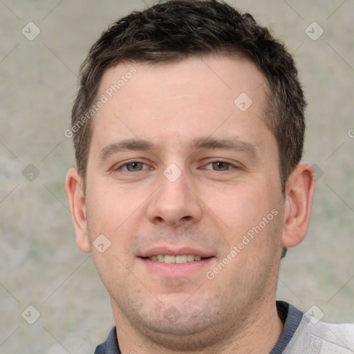 Joyful white young-adult male with short  brown hair and grey eyes