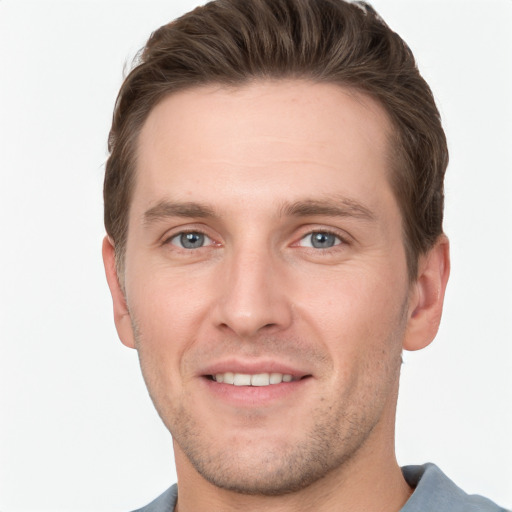 Joyful white young-adult male with short  brown hair and grey eyes